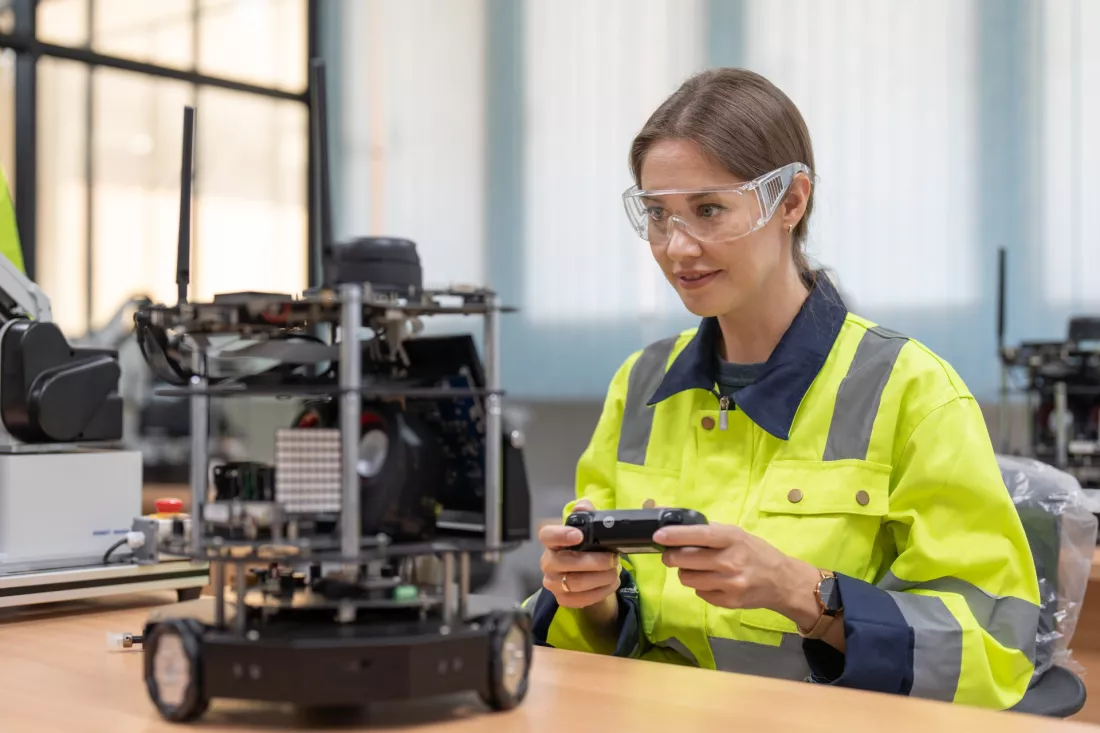 Studentka steruje robotem mobilnym w laboratorium robotyki