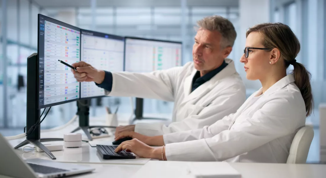 Specjalisci zdrowia publicznego analizuja dane na monitorach
