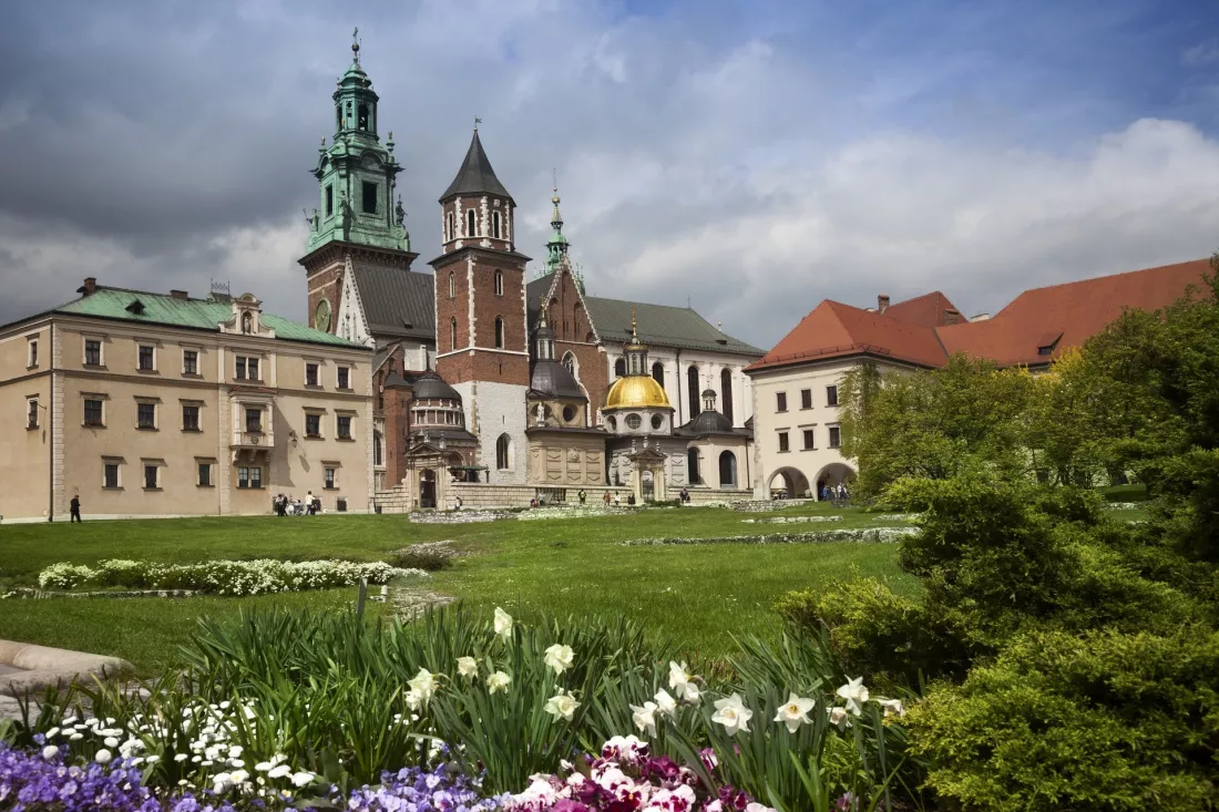 Wzgórze wawelskie w Krakowie z katedrą i zamkiem królewskim, w ogrodach przechadzają się turyści